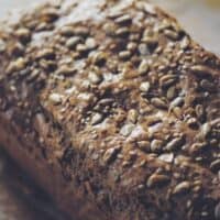 a close up of a loaf of tahini bread covered in seeds