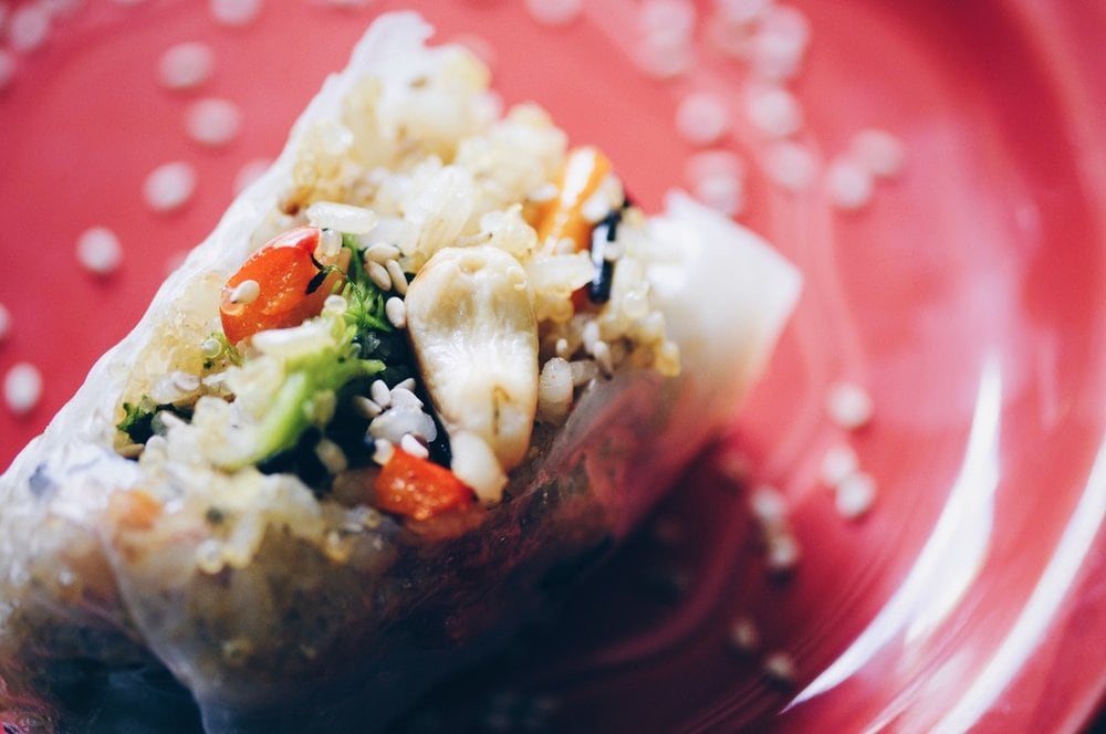 a close up of a spring roll filled with cashews and vegetables