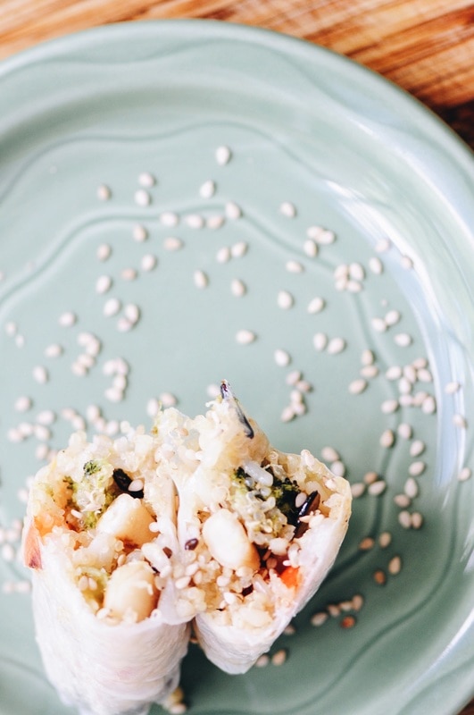 two spring rolls on a green plate sprinkled with sesame seeds