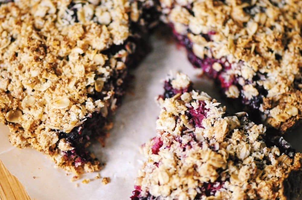  A luscious triple berry filling atop a crisp crust & topped with a delightful coconut crumble makes for one easy, healthy and delicious gluten-free and vegan dessert! #berrycrumble #vegan #glutenfree #coconut #oat #almondcrust #healthydessert #refinedsugarfree 