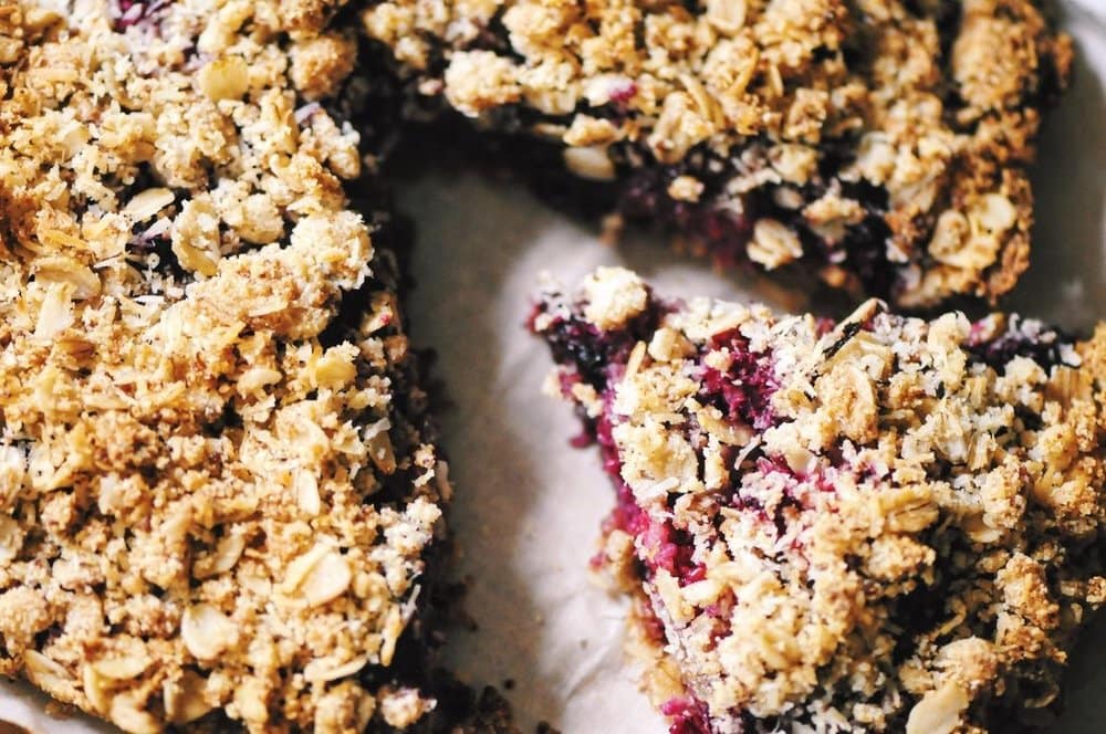  A luscious triple berry filling atop a crisp crust & topped with a delightful coconut crumble makes for one easy, healthy and delicious gluten-free and vegan dessert! #berrycrumble #vegan #glutenfree #coconut #oat #almondcrust #healthydessert #refinedsugarfree 