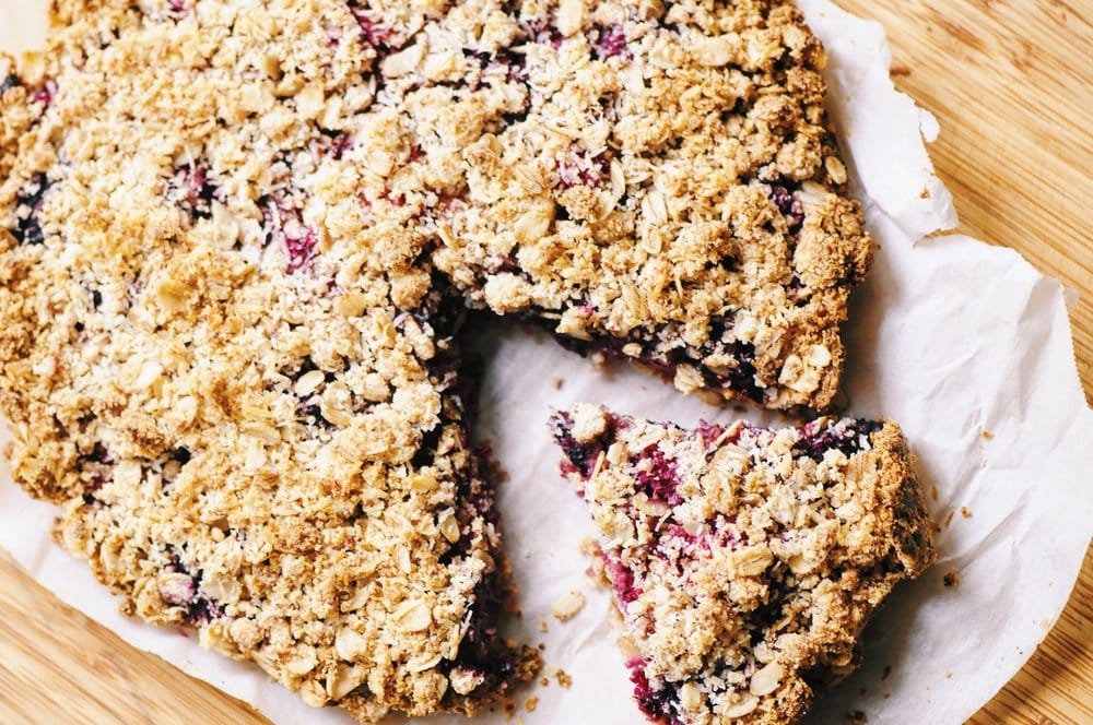  A luscious triple berry filling atop a crisp crust & topped with a delightful coconut crumble makes for one easy, healthy and delicious gluten-free and vegan dessert! #berrycrumble #vegan #glutenfree #coconut #oat #almondcrust #healthydessert #refinedsugarfree 