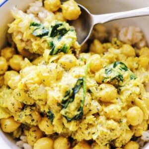 A bowl of coconut chickpea spinach curry served over rice.