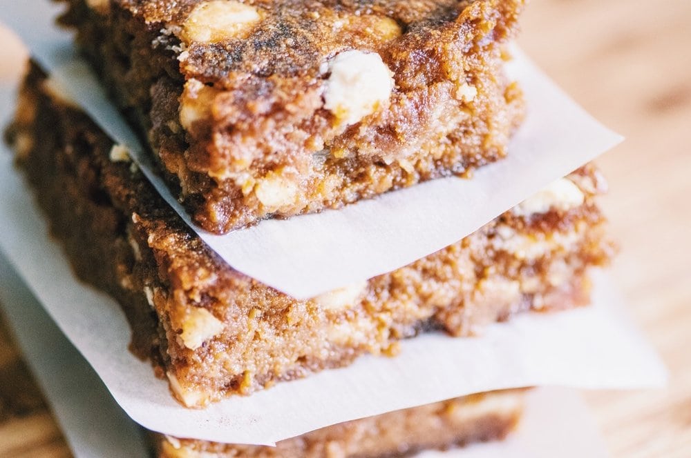  These chewy and delicious pumpkin bars make the perfect autumn treat! They are flavored by a hint of chai spices and are spotted with decadent white chocolate chips. They are not only easy to make, they also store great and are also gluten-free! You will be sold at first bite, I promise! #bars #glutenfreepumpkinbars #whitechocolatebars #chaispiced #chaibars #glutenfreedessert #autumn #glutenfree 