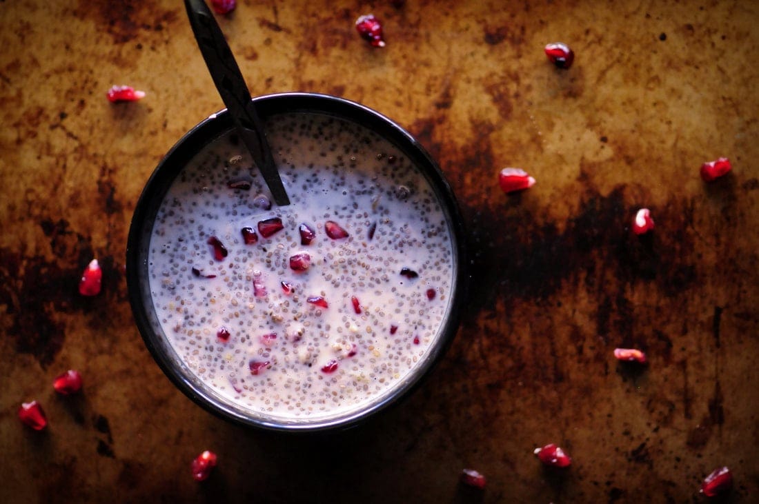 pomegranate pudding in a black bowl