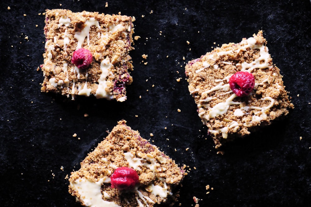  These Raspberry Gingerbread Crumble Bars are made with a delectably spiced buttery oat crust filled with a luscious raspberry chia seed jam and then drizzled with white chocolate! They make for one beautiful, easy, delicious and festive gluten-free treat! #raspberrybars #gingerbreadbars #glutenfreebars #gingerbread #chiaseedbars #whitechocolate 
