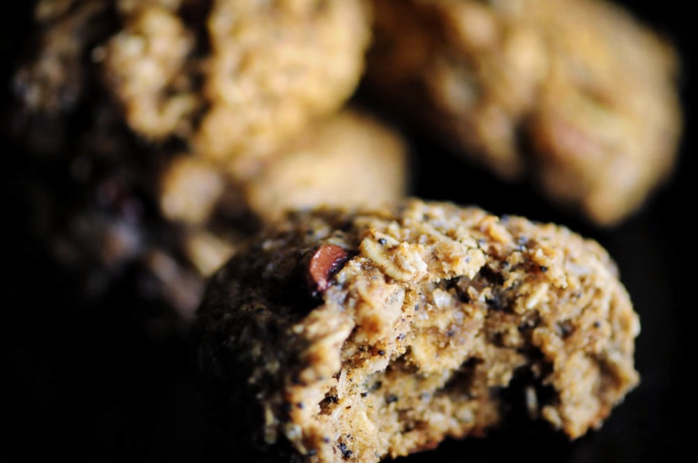 Close up of trail mix cookies with a bite taken out of one.