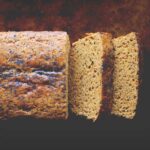 a top view of a gluten free lemon poppy seed bread made with chickpea flour on a dark backgroun