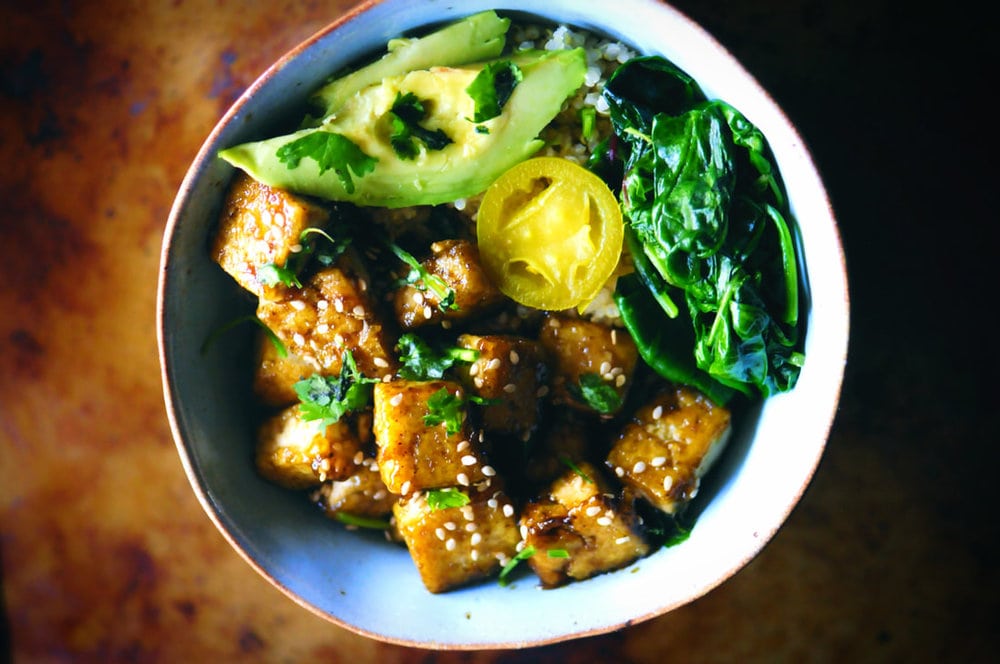  A beautiful vibrant green power bowl filled with quinoa, sweet and spicy tofu, mixed wilted greens, jalapeño slices, avocado, cilantro and sesame seeds. This makes an absolutely delicious vegan and gluten-free high protein lunch or dinner! #sweetandspicytofu #buddhabowl #quinoabowl #vegandinner #tofubowl #sweetandspicy #glutenfreelunch 