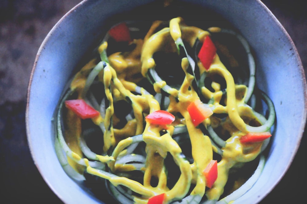  A refreshing, light, healthy and easy spiralized cucumber noodle dish served alongside a spicy turmeric tahini sauce and garnished with bell pepper for a delightful crunch. Gluten-free, vegan, and oh so delicious! #spiralizedcucumber #cucumbernoodles #turmerictahinisauce #spicycucumbernoodles #zoodles 