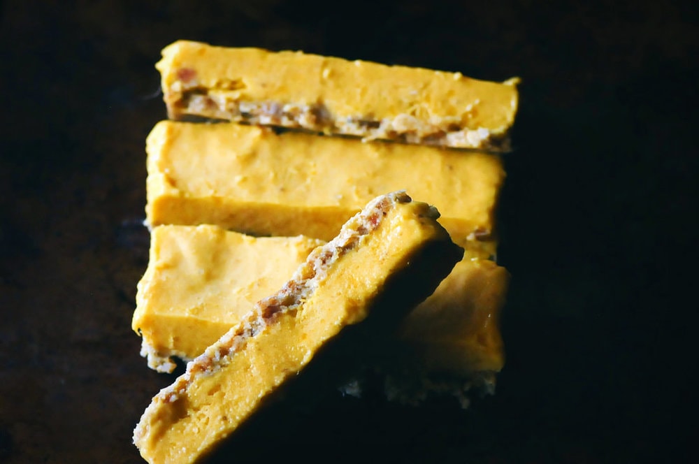  These date-free Vegan & Gluten-Free Mango Nice Cream Bars make for one easy, healthy, delicious, and refreshing frozen treat! A creamy frozen mango banana ice cream filling sits atop a chewy cardamom almond crust in this delightful dessert. #veganicecreambars #nicecream #nicecreambars #rawbars #veganbars #mangobars #mangonicecream #glutenfreeicecreambars 