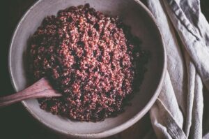 a top view of a big white bowl filled with cooked red quinoa