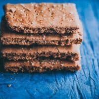 a stack of gluten free graham crackers on blue backdrop