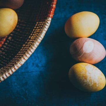 naturally dyed easter eggs on a blue wooden backdrop