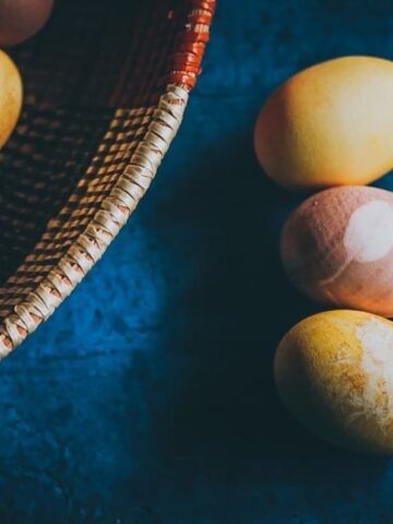 naturally dyed easter eggs on a blue wooden backdrop