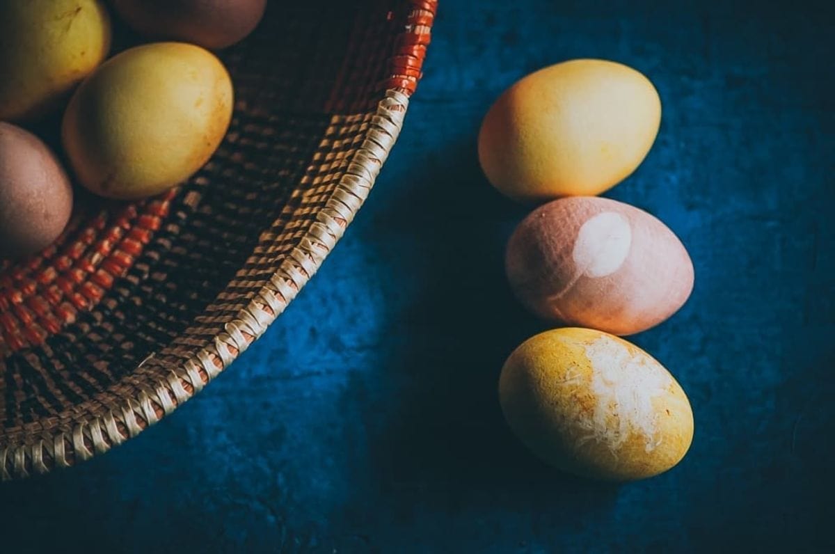 naturally dyed easter eggs on a blue wooden backdrop