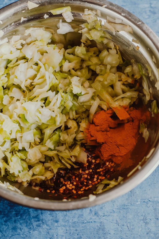  This probiotic rich Spicy Sauerkraut recipe with turmeric, red chili flakes, and black peppercorns is bursting with flavor and anti-inflammatory + gut health benefits! Easy, healthy, vegan, gluten-free and DELICIOUS! Learn all about how to make sauerkraut, health benefits, and more in this informative recipe post! #turmericsauerkraut #spicysauerkraut #howtomakesauerkraut 