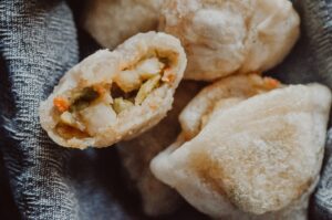 a close up of a gluten free samosa cut in half revealing filling