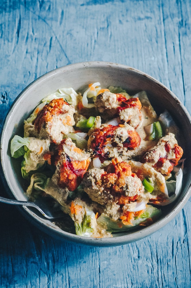   This delicious Roasted Cauliflower Salad makes for one healthy, easy, delicious and filling dish topped with a delightful Sweet and Spicy BBQ Roasted Cauliflower packed with loads of flavor and spice. Contrasted with fresh, crisp iceberg lettuce, and my pumpkin seed vegan ranch dressing, this vegan salad is a medley of pleasing textures, too! #roastedcauliflowersalad #bbqcauliflowersalad #cauliflowerwingsalad  