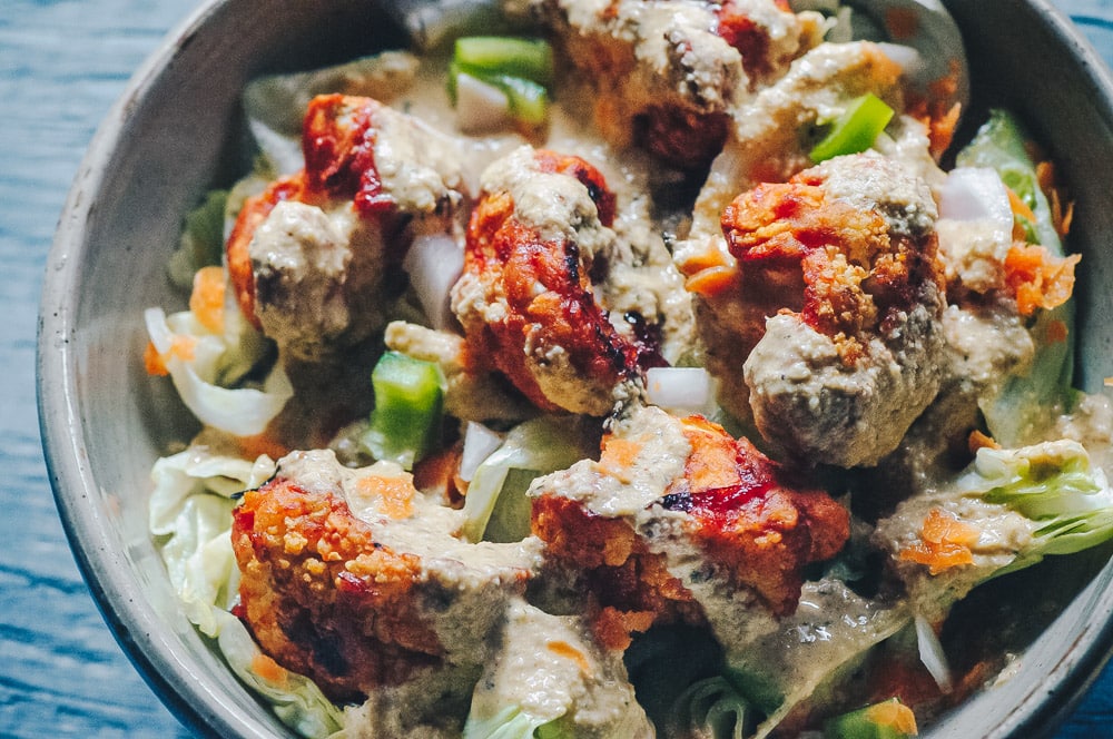   This delicious Roasted Cauliflower Salad makes for one healthy, easy, delicious and filling dish topped with a delightful Sweet and Spicy BBQ Roasted Cauliflower packed with loads of flavor and spice. Contrasted with fresh, crisp iceberg lettuce, and my pumpkin seed vegan ranch dressing, this vegan salad is a medley of pleasing textures, too! #roastedcauliflowersalad #bbqcauliflowersalad #cauliflowerwingsalad  