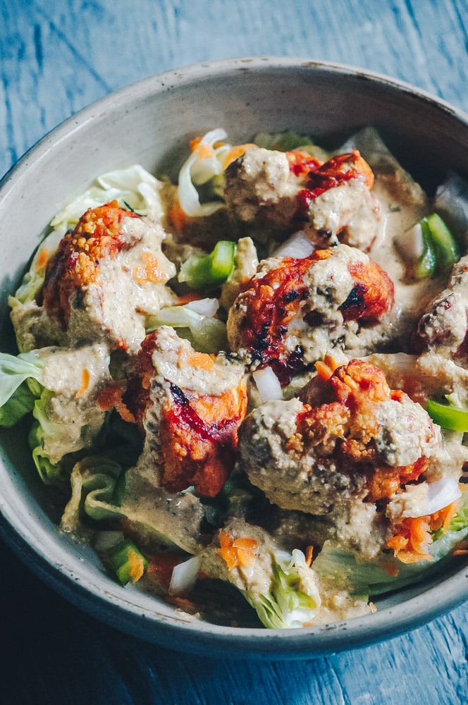   This delicious Roasted Cauliflower Salad makes for one healthy, easy, delicious and filling dish topped with a delightful Sweet and Spicy BBQ Roasted Cauliflower packed with loads of flavor and spice. Contrasted with fresh, crisp iceberg lettuce, and my pumpkin seed vegan ranch dressing, this vegan salad is a medley of pleasing textures, too! #roastedcauliflowersalad #bbqcauliflowersalad #cauliflowerwingsalad  