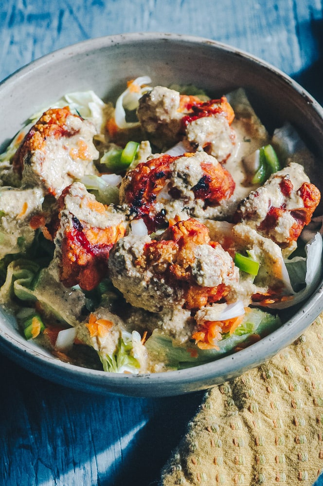   This delicious Roasted Cauliflower Salad makes for one healthy, easy, delicious and filling dish topped with a delightful Sweet and Spicy BBQ Roasted Cauliflower packed with loads of flavor and spice. Contrasted with fresh, crisp iceberg lettuce, and my pumpkin seed vegan ranch dressing, this vegan salad is a medley of pleasing textures, too! #roastedcauliflowersalad #bbqcauliflowersalad #cauliflowerwingsalad  