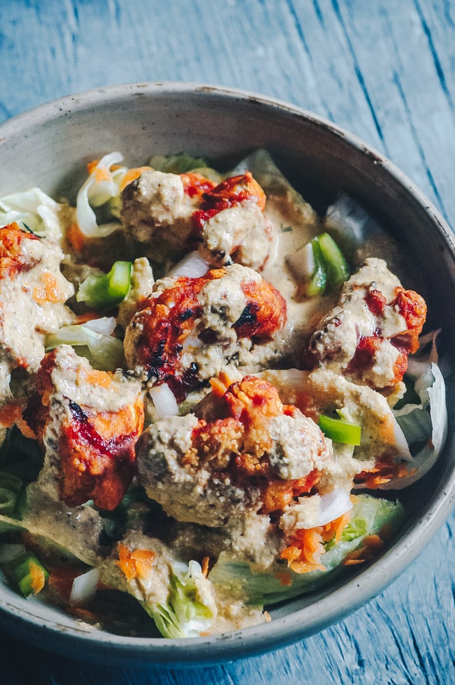   This delicious Roasted Cauliflower Salad makes for one healthy, easy, delicious and filling dish topped with a delightful Sweet and Spicy BBQ Roasted Cauliflower packed with loads of flavor and spice. Contrasted with fresh, crisp iceberg lettuce, and my pumpkin seed vegan ranch dressing, this vegan salad is a medley of pleasing textures, too! #roastedcauliflowersalad #bbqcauliflowersalad #cauliflowerwingsalad  