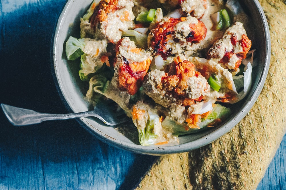   This delicious Roasted Cauliflower Salad makes for one healthy, easy, delicious and filling dish topped with a delightful Sweet and Spicy BBQ Roasted Cauliflower packed with loads of flavor and spice. Contrasted with fresh, crisp iceberg lettuce, and my pumpkin seed vegan ranch dressing, this vegan salad is a medley of pleasing textures, too! #roastedcauliflowersalad #bbqcauliflowersalad #cauliflowerwingsalad  