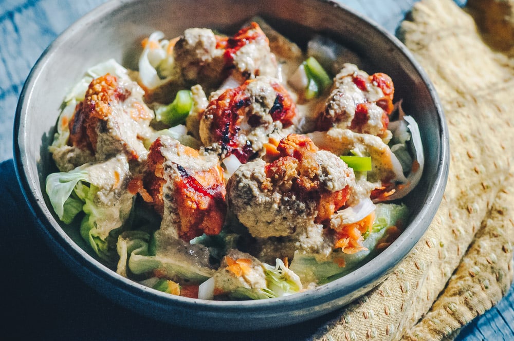   This delicious Roasted Cauliflower Salad makes for one healthy, easy, delicious and filling dish topped with a delightful Sweet and Spicy BBQ Roasted Cauliflower packed with loads of flavor and spice. Contrasted with fresh, crisp iceberg lettuce, and my pumpkin seed vegan ranch dressing, this vegan salad is a medley of pleasing textures, too! #roastedcauliflowersalad #bbqcauliflowersalad #cauliflowerwingsalad  