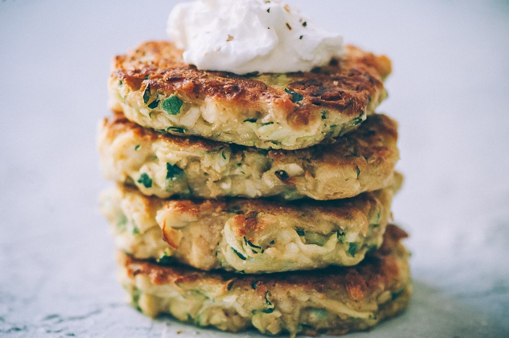  Super EASY, DELICIOUS AND HEALTHY Vegan Zucchini Fritters made with chickpea flour for that extra nutritional punch. These gluten-free vegan fritters are filled with loads of FLAVOR and could not be a tastier way to use that summer squash from your garden! #zucchinifritters #veganfritters #veganzucchinifritters #glutenfreezucchinifritters 