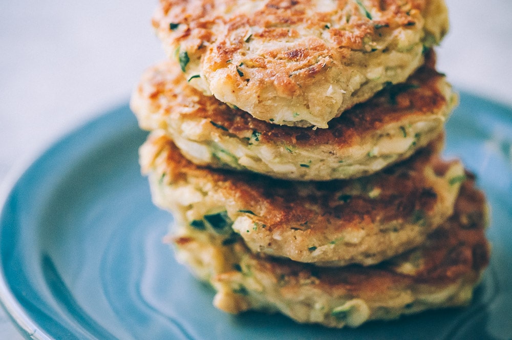  Super EASY, DELICIOUS AND HEALTHY Vegan Zucchini Fritters made with chickpea flour for that extra nutritional punch. These gluten-free vegan fritters are filled with loads of FLAVOR and could not be a tastier way to use that summer squash from your garden! #zucchinifritters #veganfritters #veganzucchinifritters #glutenfreezucchinifritters 