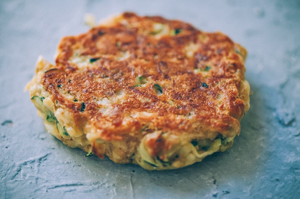  Super EASY, DELICIOUS AND HEALTHY Vegan Zucchini Fritters made with chickpea flour for that extra nutritional punch. These gluten-free vegan fritters are filled with loads of FLAVOR and could not be a tastier way to use that summer squash from your garden! #zucchinifritters #veganfritters #veganzucchinifritters #glutenfreezucchinifritters 