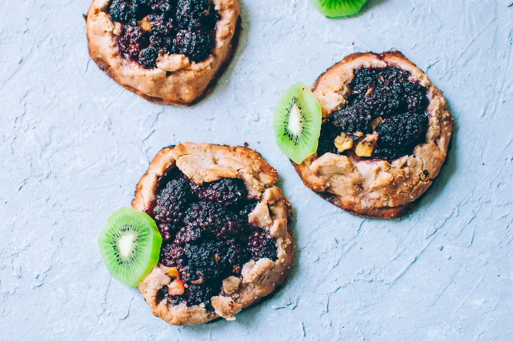   These gluten-free vegan mini rustic pies are filled with juicy blackberries and tart kiwi for a fun twist! Easy, healthy, and delicious galettes are at your fingertips! #galette #galettes #minipies #rusticepies #kiwi #blackberries #glutenfreepie #veganpie #kiwipie  