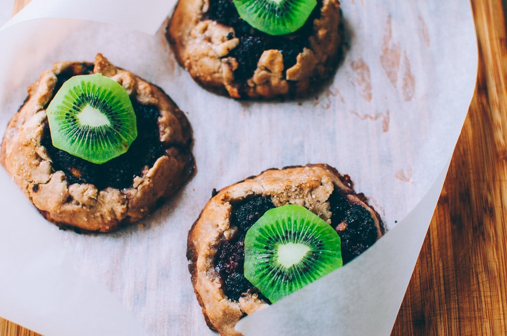   These gluten-free vegan mini rustic pies are filled with juicy blackberries and tart kiwi for a fun twist! Easy, healthy, and delicious galettes are at your fingertips! #galette #galettes #minipies #rusticepies #kiwi #blackberries #glutenfreepie #veganpie #kiwipie  