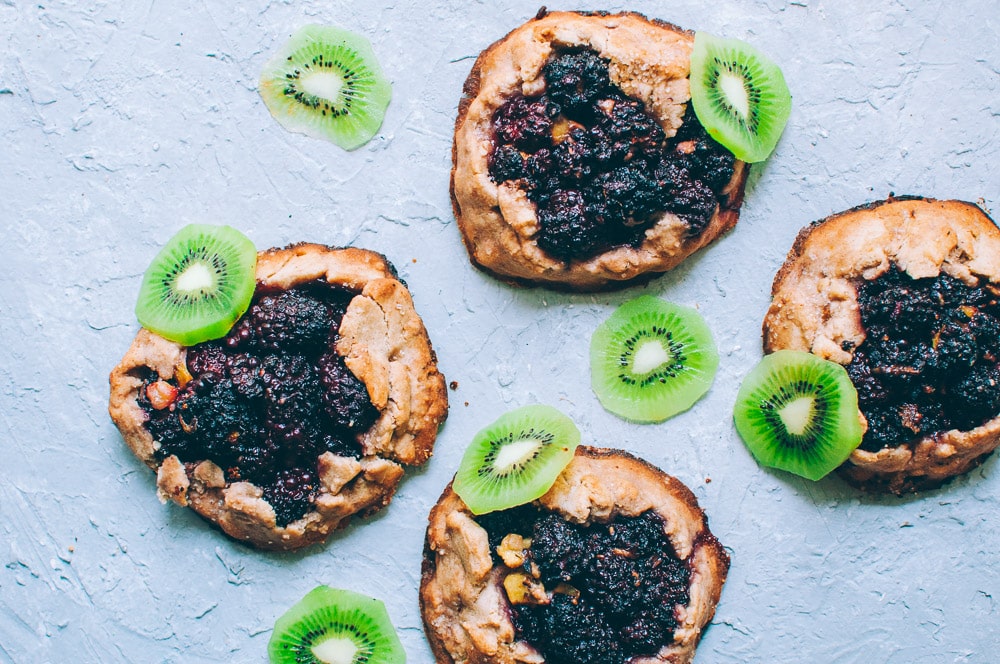   These gluten-free vegan mini rustic pies are filled with juicy blackberries and tart kiwi for a fun twist! Easy, healthy, and delicious galettes are at your fingertips! #galette #galettes #minipies #rusticepies #kiwi #blackberries #glutenfreepie #veganpie #kiwipie  