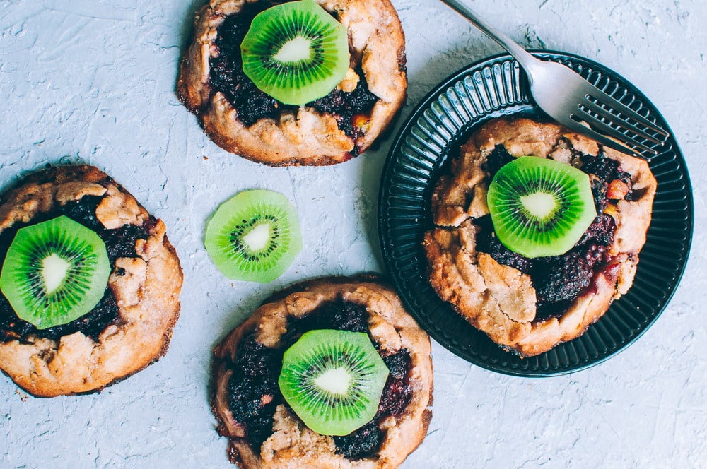   These gluten-free vegan mini rustic pies are filled with juicy blackberries and tart kiwi for a fun twist! Easy, healthy, and delicious galettes are at your fingertips! #galette #galettes #minipies #rusticepies #kiwi #blackberries #glutenfreepie #veganpie #kiwipie  