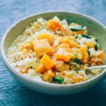 butternut squash curry in a white bowl served with rice