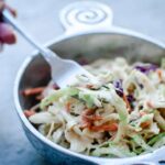 a pewter bowl filled with vegan coleslaw