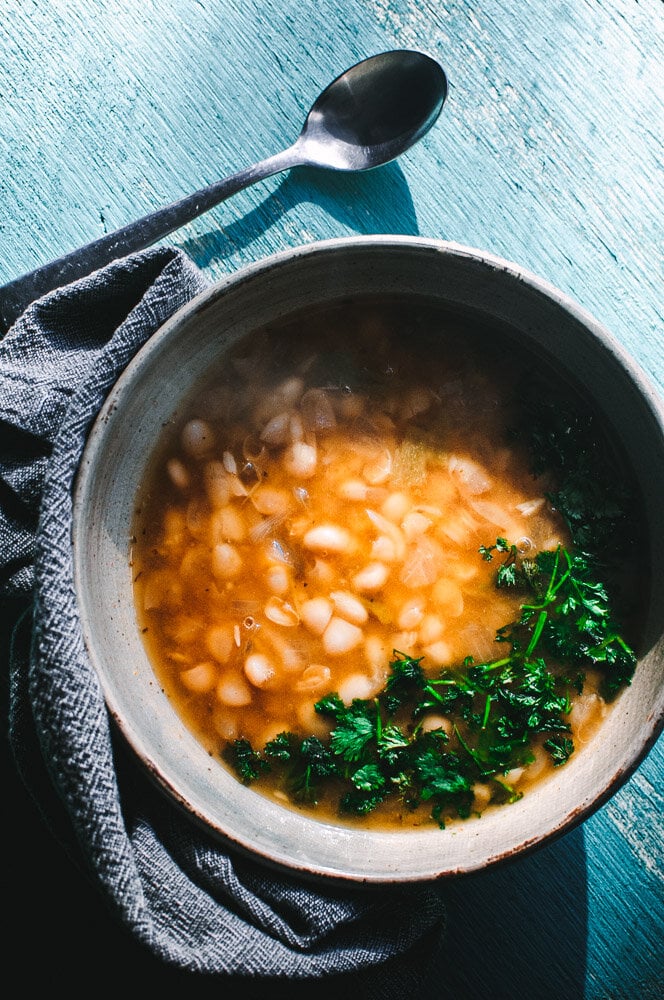   This comforting and heart-warming White Bean Soup is packed with flavorful Mexican spices for a truly delicious vegan soup recipe that is healthy, easy to make and can be made with soaked or unsoaked dry white beans! Both Instant Pot pressure cooker and stovetop instructions are included for this spicy, smoky, keto friendly soup! #whitebeansoup #whitebeansoupvegetarian #whitebeansoupvegan #instantpotwhitebeansoup  