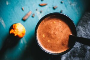 a top shot of a black mug of pumpkin spice hot chocolate