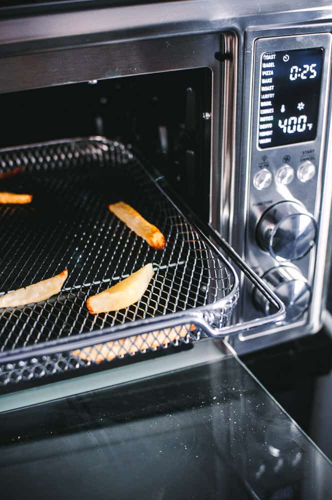 a cosori oven air fryer open with a tray of fries visible