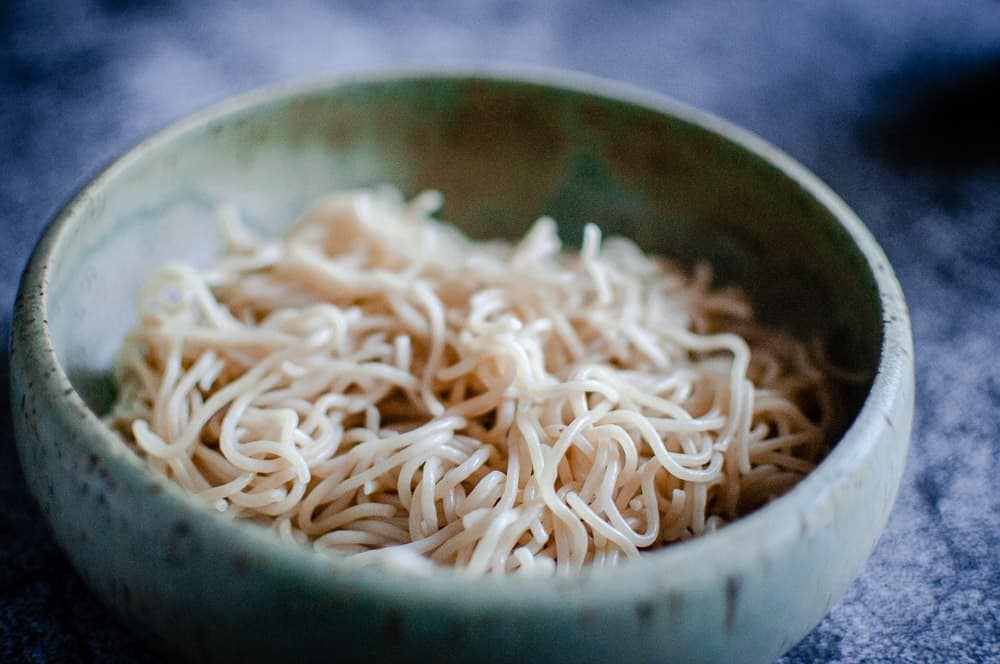 gluten free ramen noodles in a sage green bowl on gray backdrop