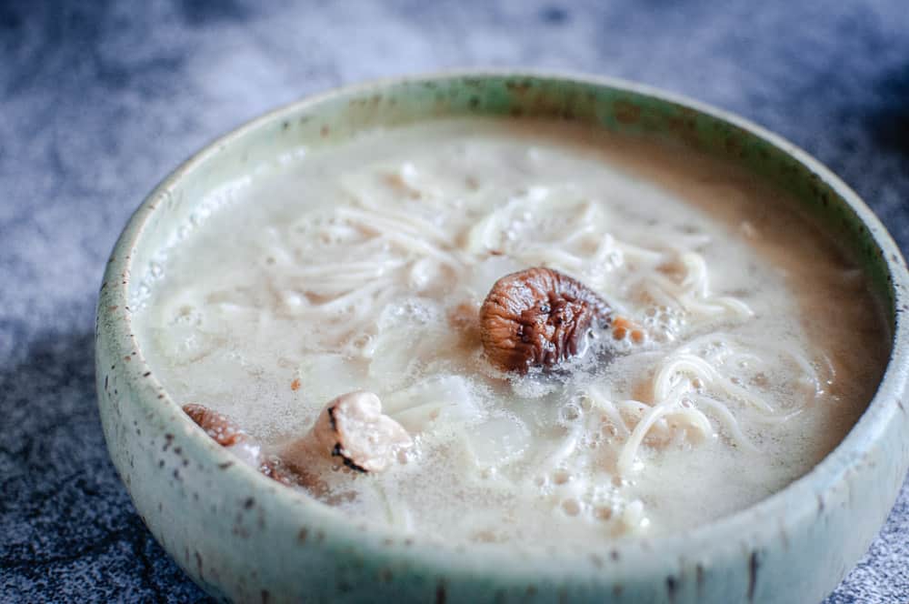 a bowl filled with gluten free ramen noodles and vegan broth