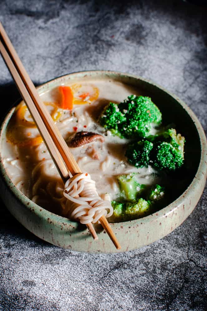 vegan ramen twisted on chopsticks resting on bowl