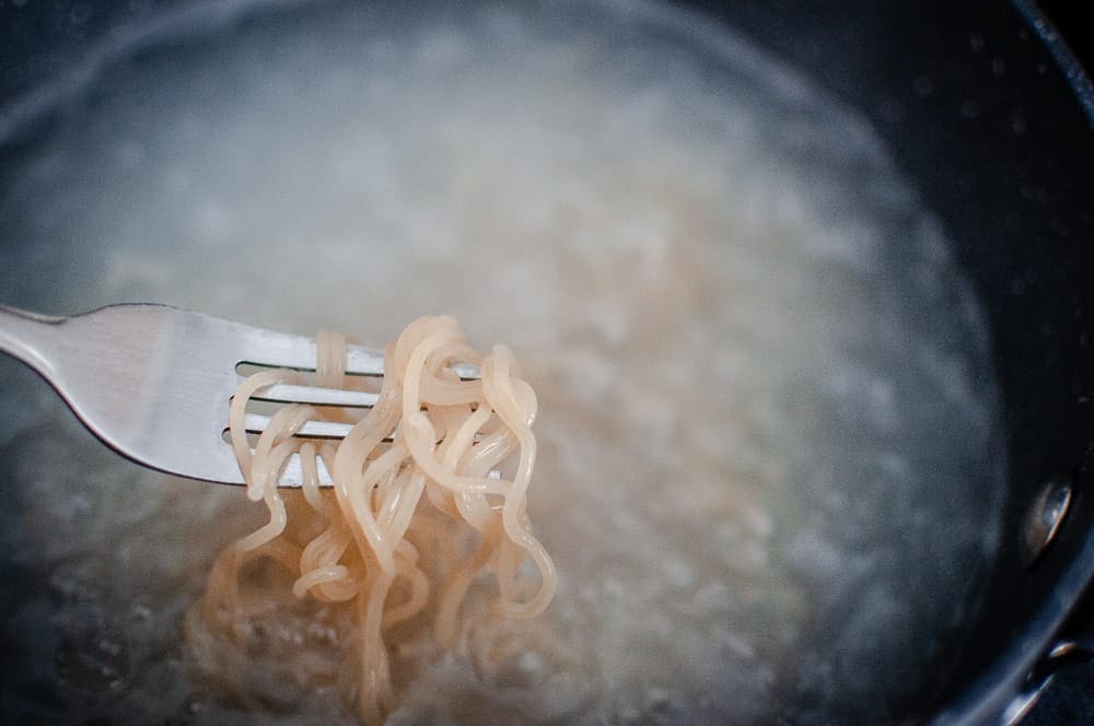 a close up shot of ramen noodles wrapped around a fork