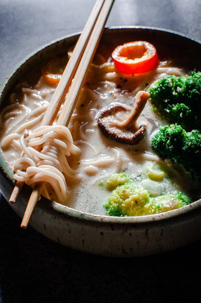 light hitting chopsticks wrapped with ramen noodles