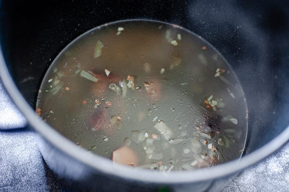 ramen broth in large black stock pot