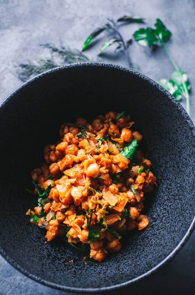 a black bowl filled with spicy moroccan chickpeas