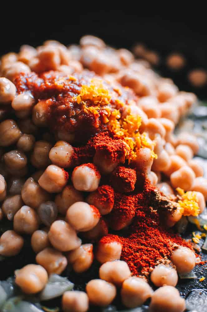 a mound of chickpeas topped with moroccan spices and orange zest