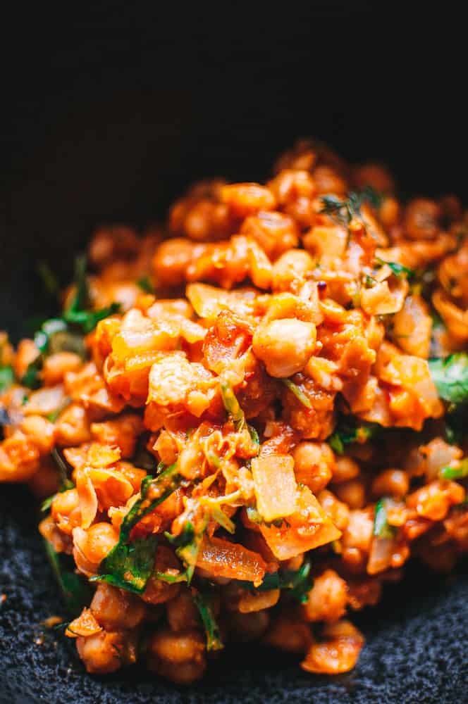 a closeup of orange harissa chickpes